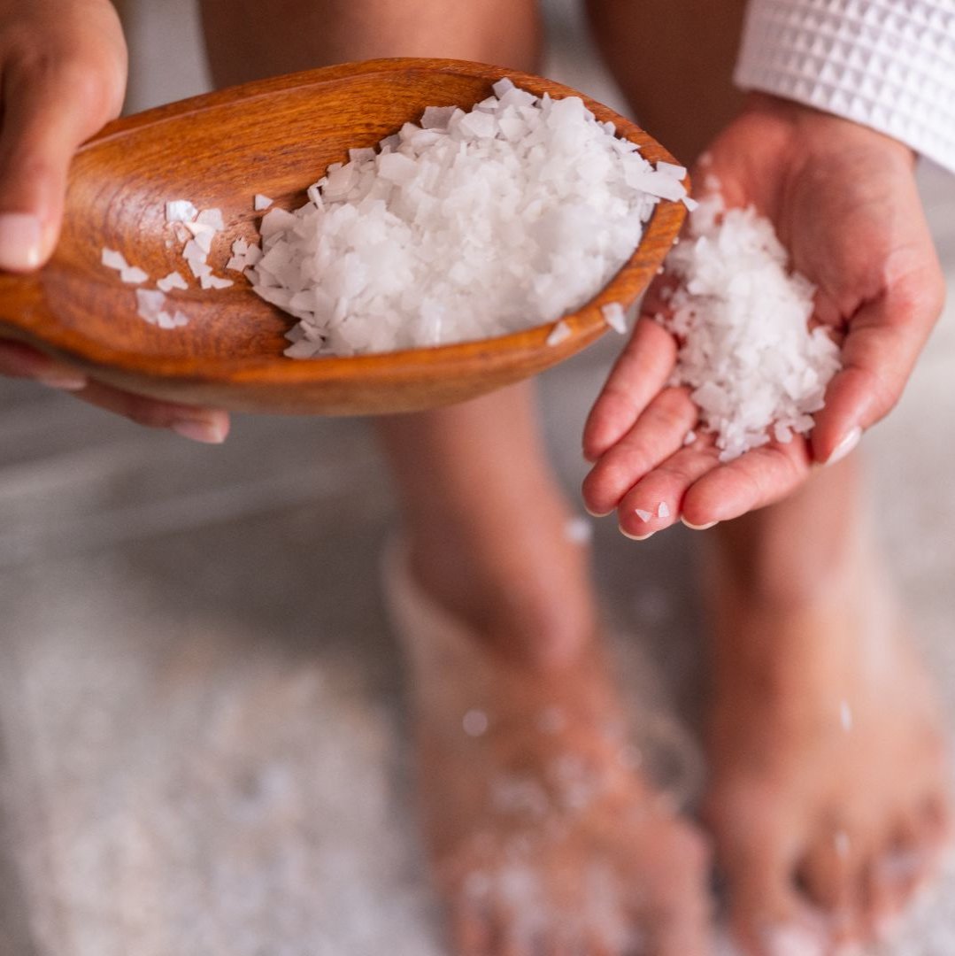 Magnesium flakes in the hands of a women preparing for foot bath